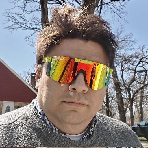 The administrator: a man in a grey sweater and large mirrored sunglasses, outdoors on a bright winter day.